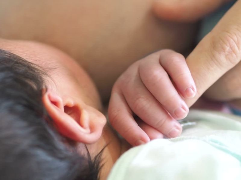 majka doji bebu dok je beba drži za prst